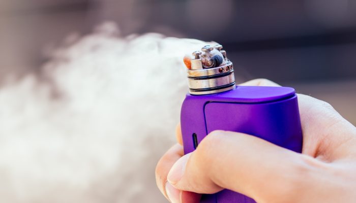purple-vape-in-a-mans-hand-on-a-modern-background-DC5PCV8